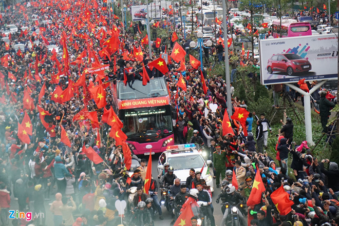 越南男足亚锦赛获亚军凯旋，民众举着*旗国**夹道欢迎