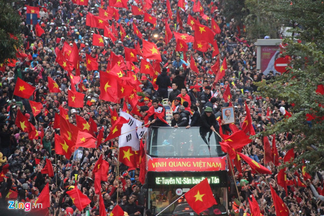 越南男足亚锦赛获亚军凯旋，民众举着*旗国**夹道欢迎