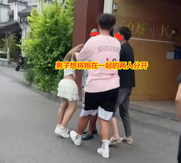 女子移情黑人男子，男友上前想将二人分开，女子哭着抱紧不肯松手